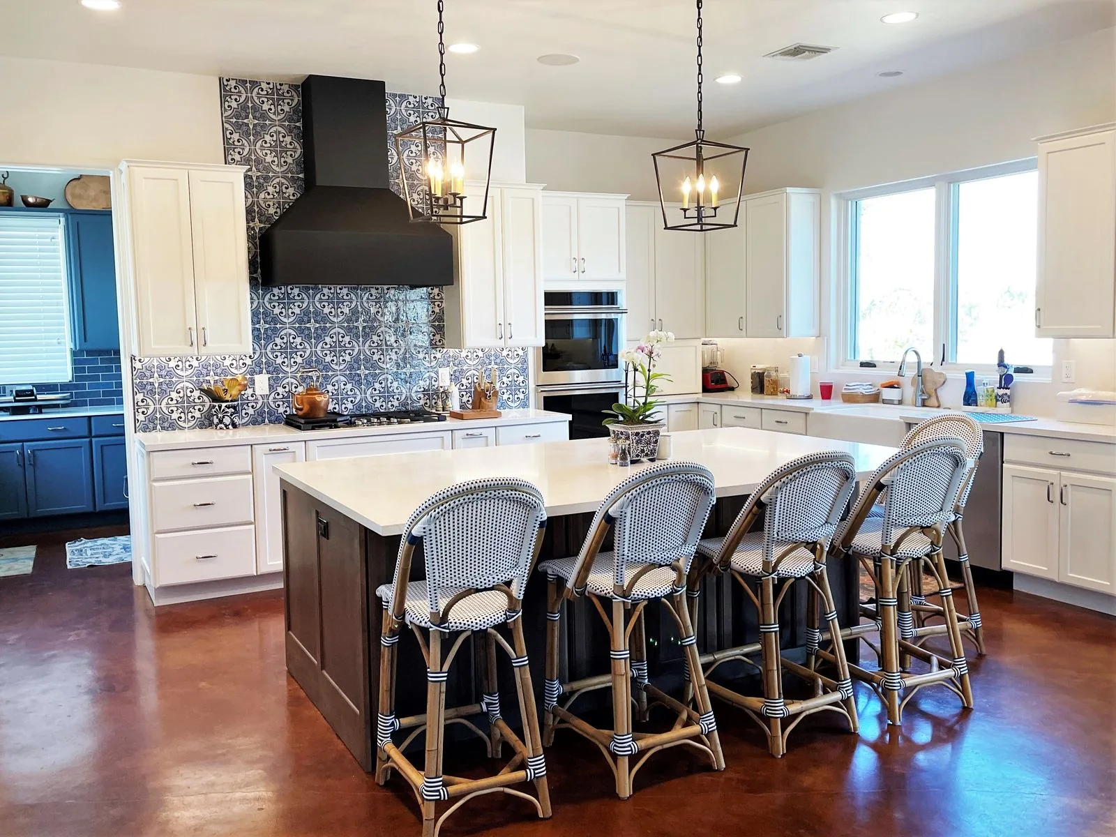 A remodeled Tucson kitchen with a white shaker cabinetry, a quartz island and patterned tile behind the range