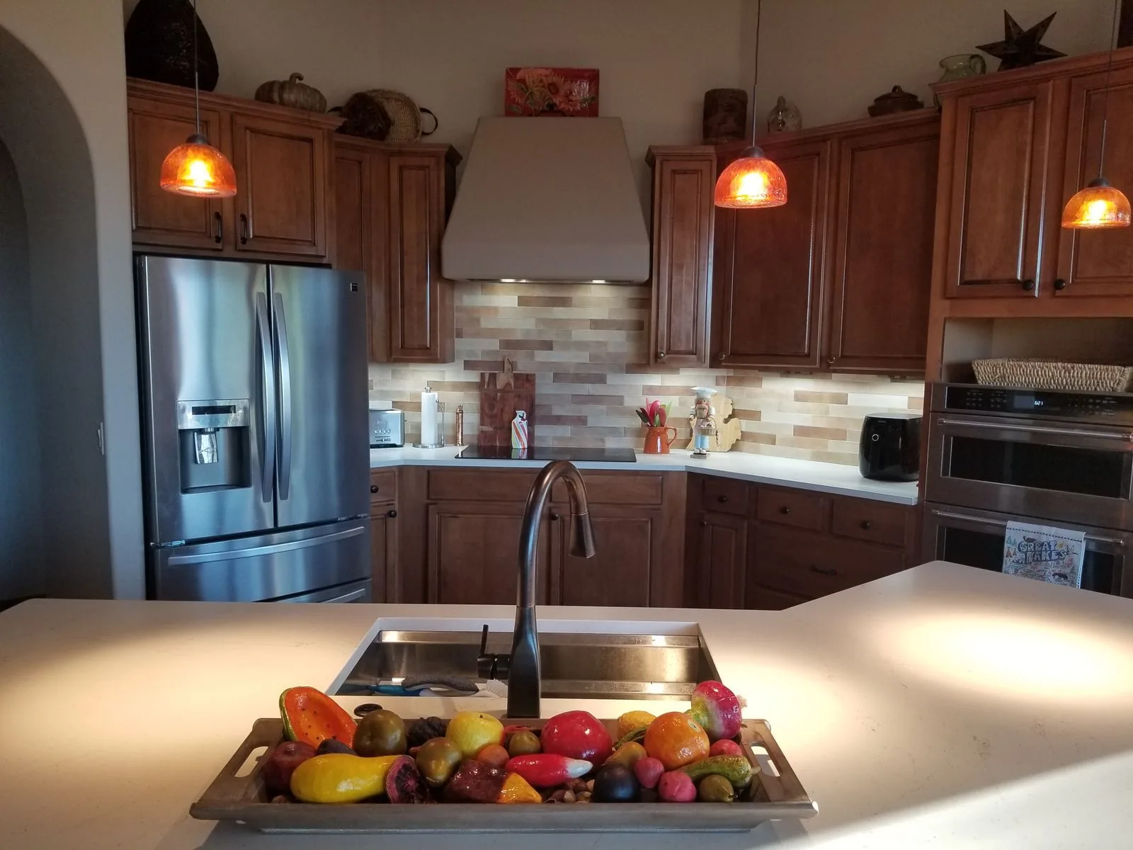 Warm kitchen remodel with wood cabinetry and a stone backsplash